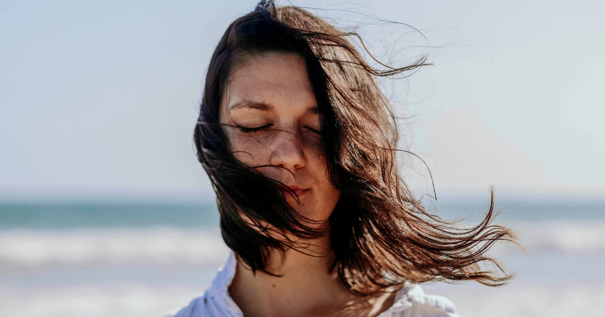 Frau am windigen Strand