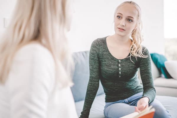 Junge Frau hat ein Gespräch mit einer Ärztin in der Jugendpsychosomatik-Therapie der BetaGenese Klinik in Bonn.