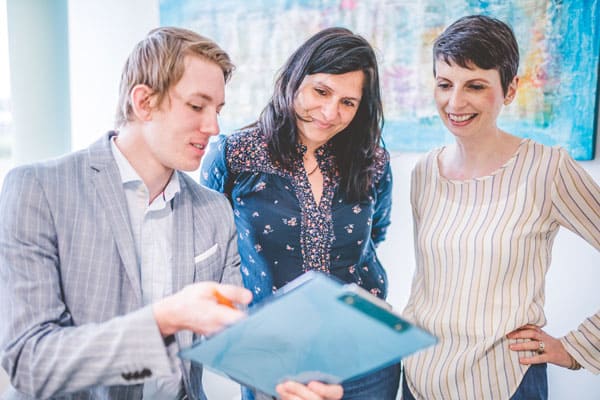 Drei Personen besprechen Patientenakten