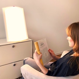 Patientin liest Buch während der Lichttherapie