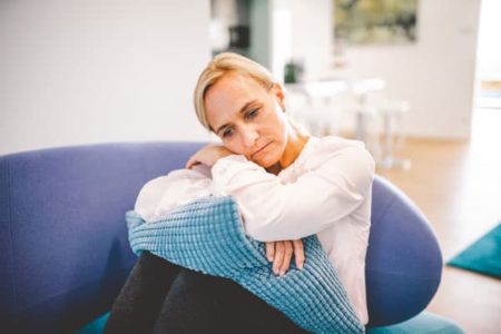 Frau mit Depression sitzt auf Sofa