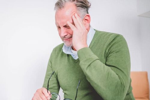 Mann mit Kopfschmerzen bei Burn-out-Therapie in Bonn.