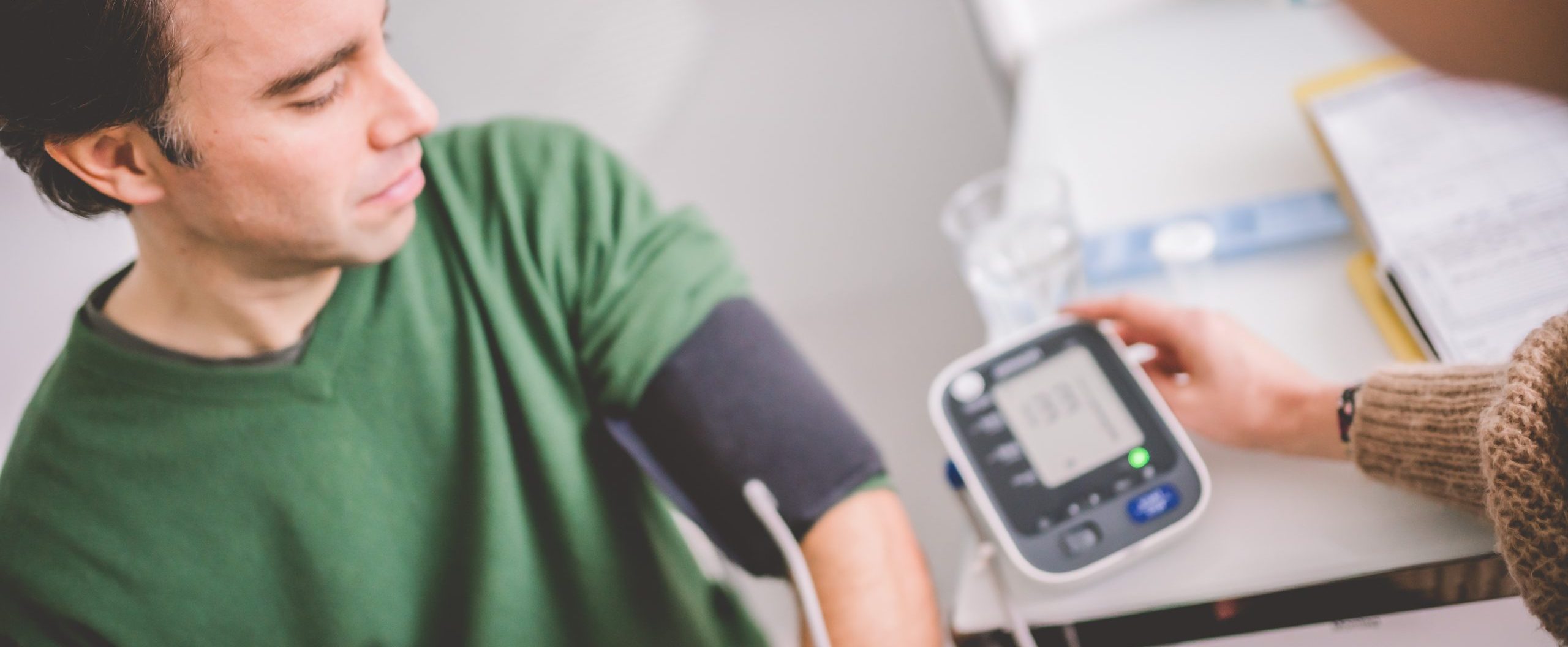 Ein junger Mann bekommt seinen Blutdruck gemessen