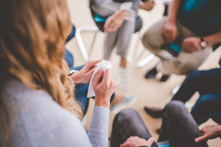 Gruppentherapie Patientin mit Taschentuch