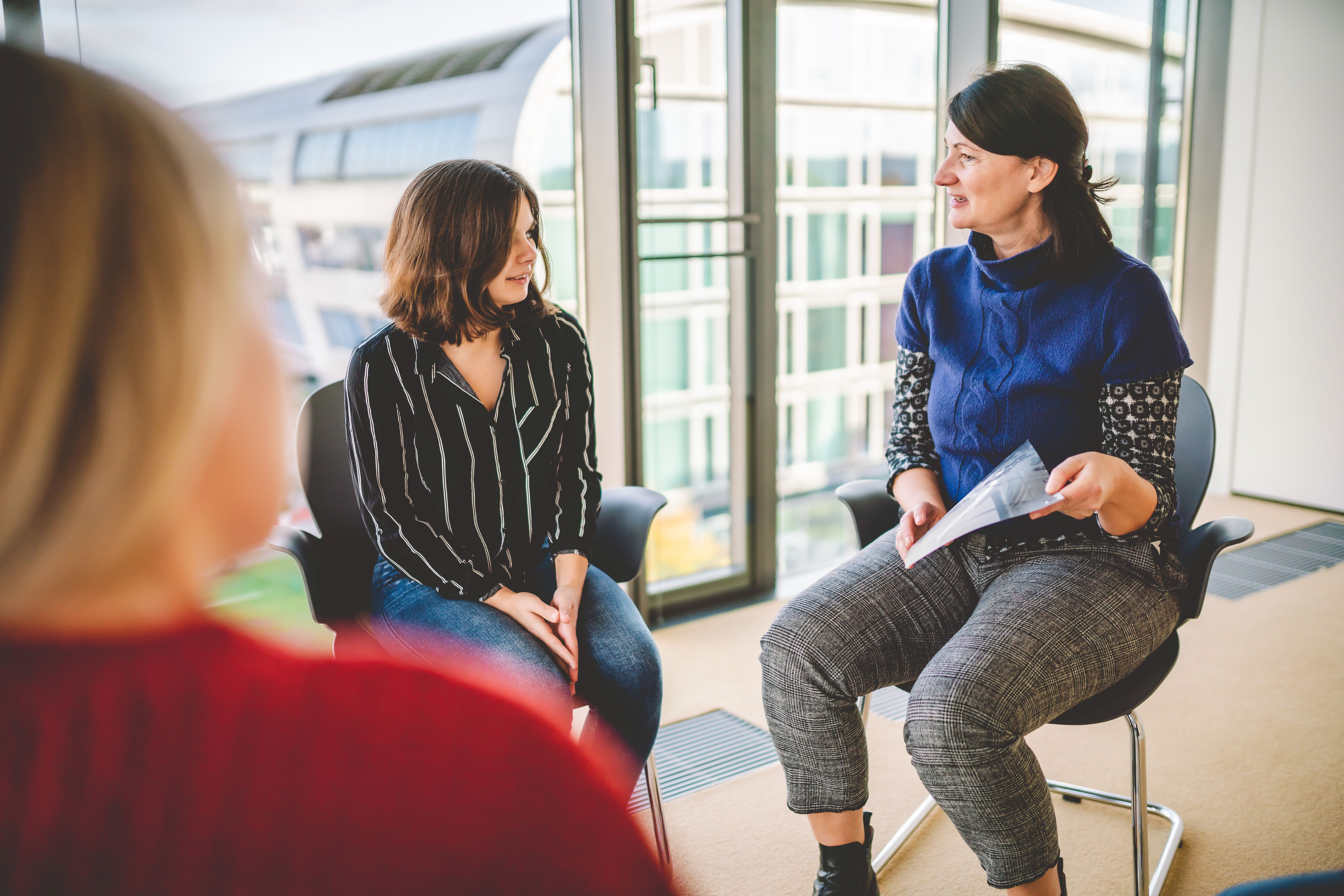 Drei Personen in der Gruppentherapie.