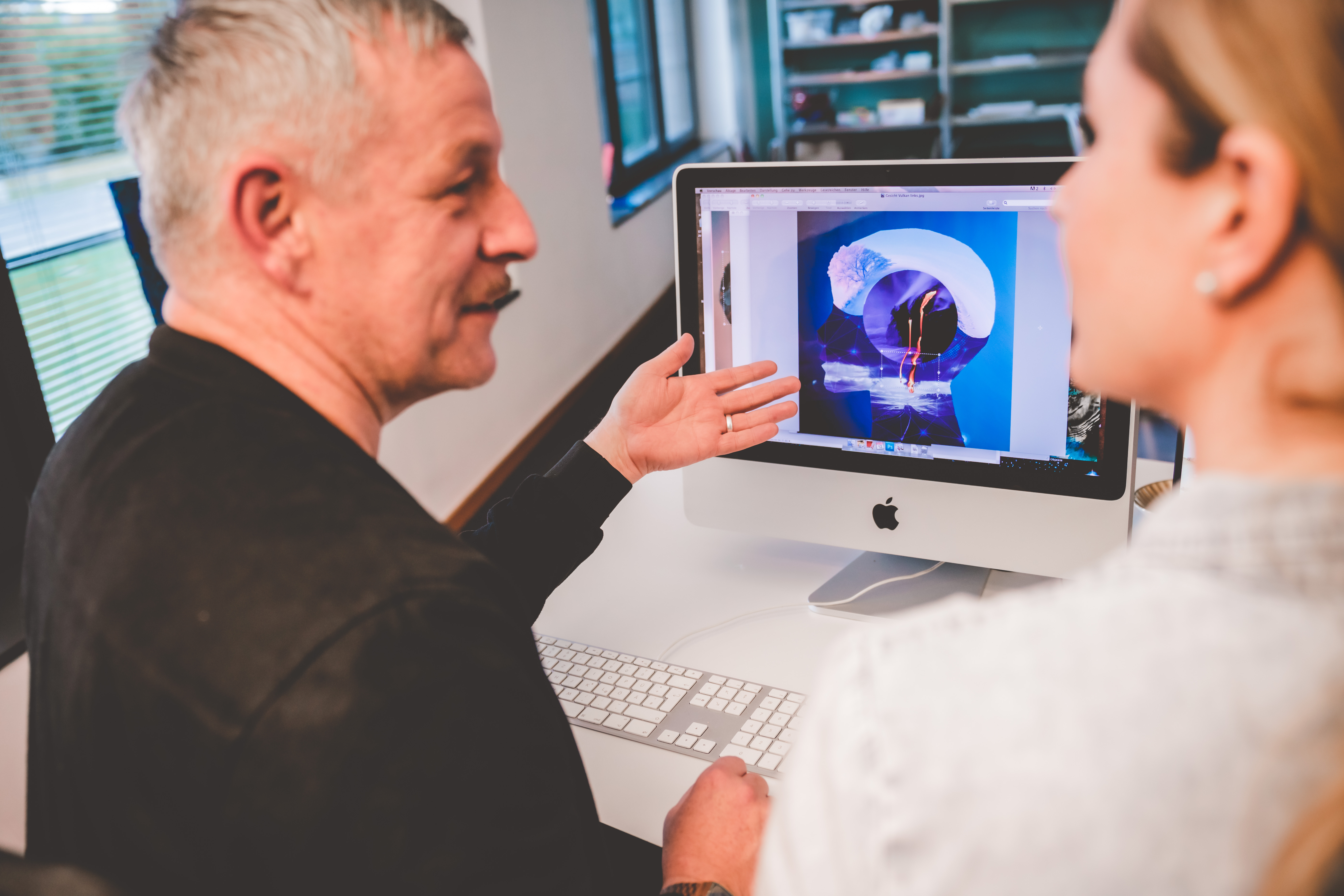 Kunsttherapeut Herr Branger sitzt mit einer Patientin vor dem Computer und erklärt was.