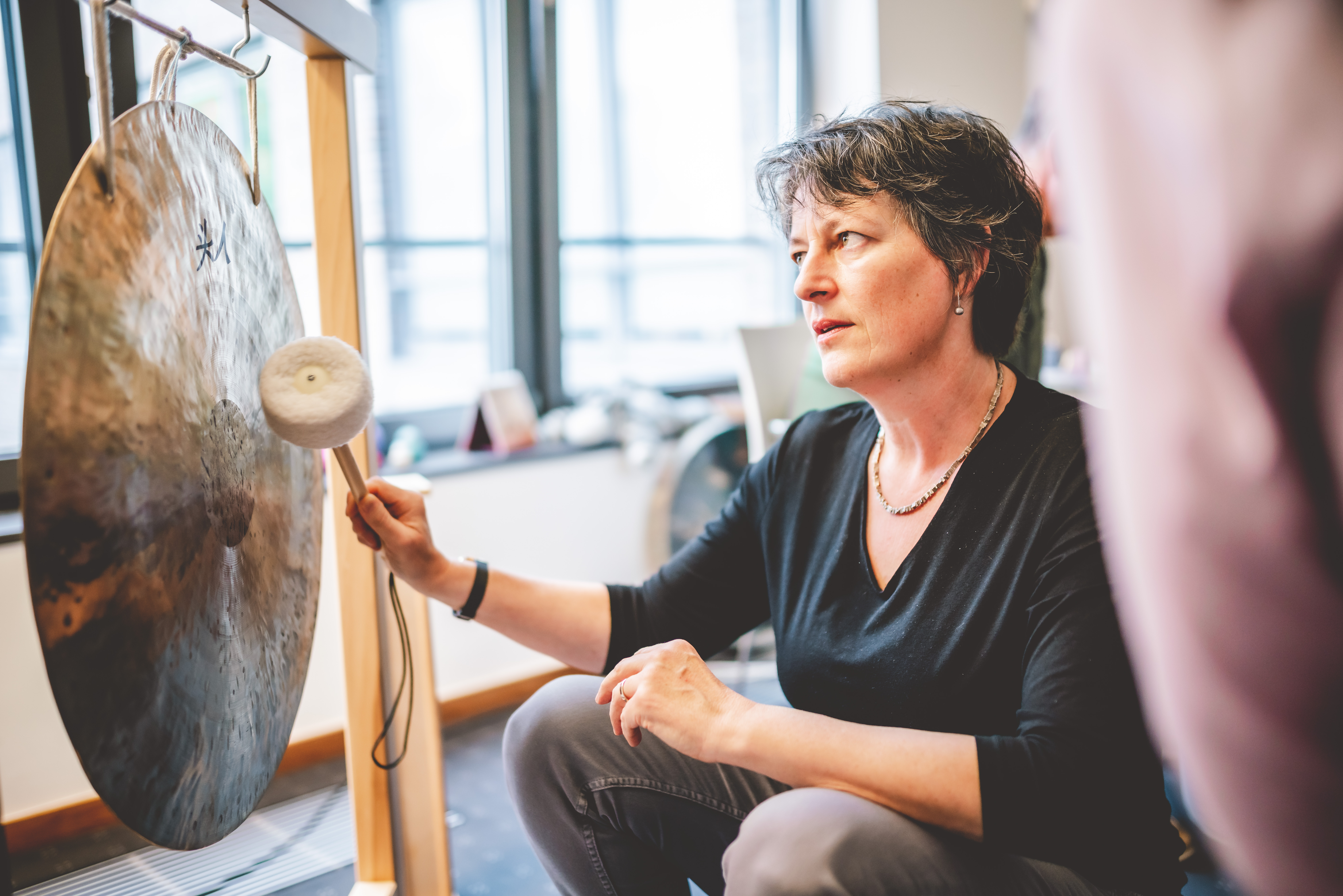 Nahaufnahme von Frau Thüringer am Gong in der Musiktherapie.