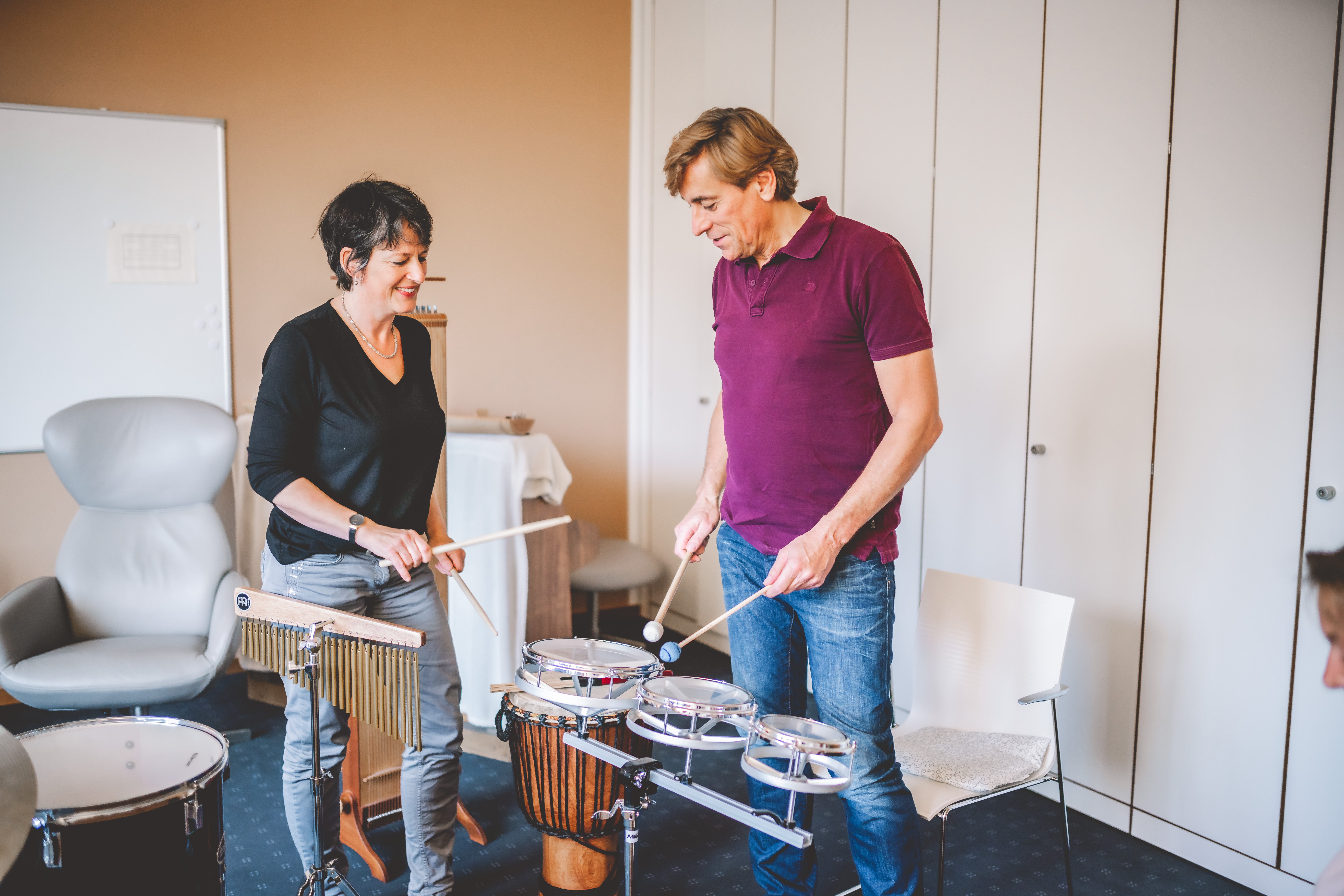 Musiktherapie an den Trommeln mit Frau Thüringer und einem Patienten.