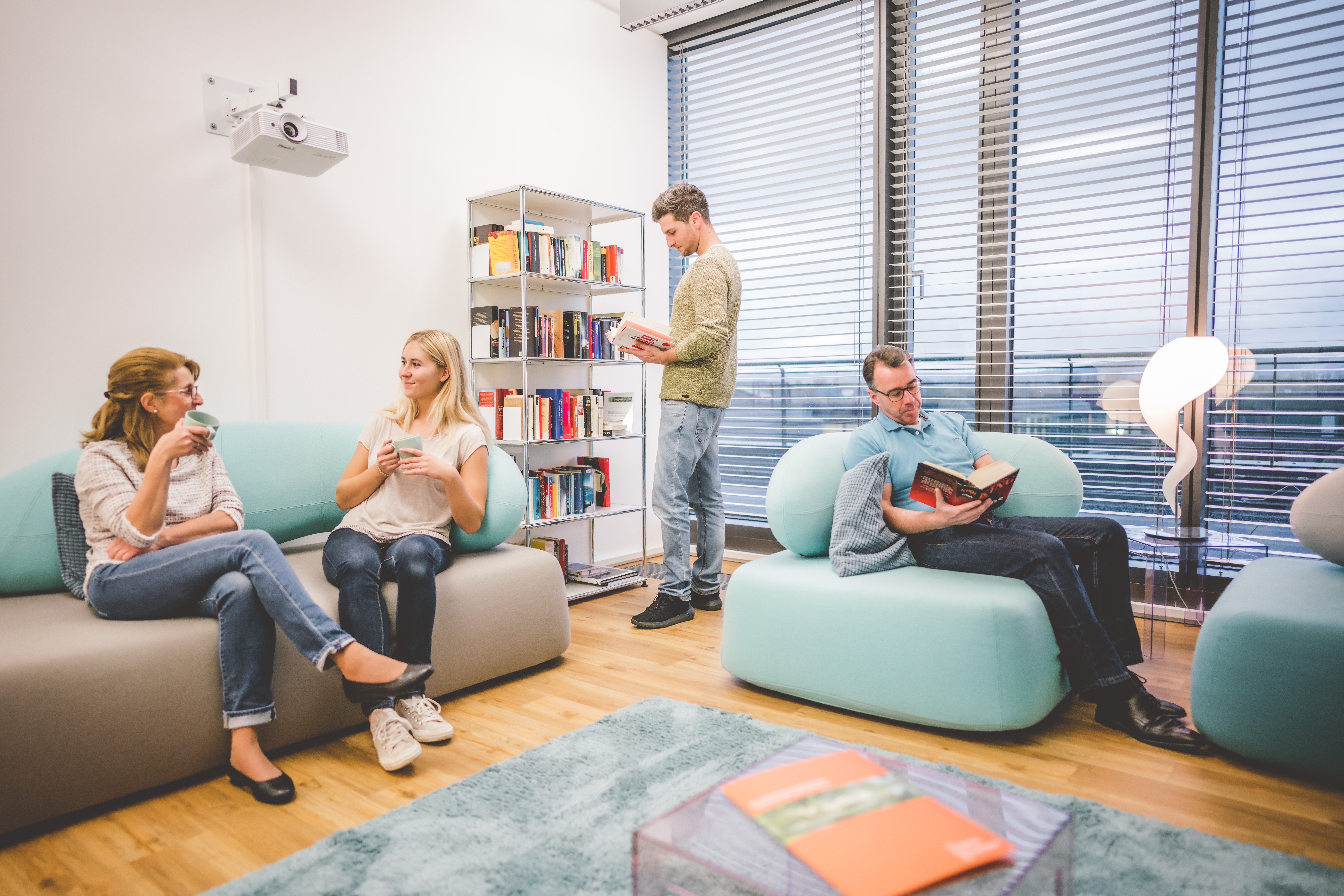 Patienten im Wartebereich am reden und lesen.