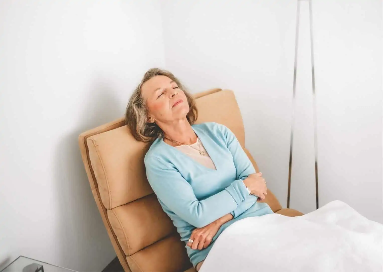 Patientin sitzt mit geschlossenen Augen auf einem Sessel.